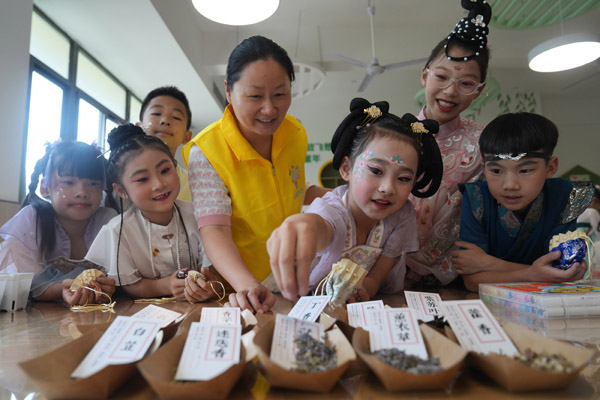 志愿者指导孩子们制作香囊。西南大学供图