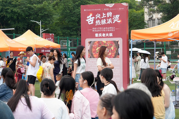 学生在活动现场一边品尝美食,一边寻找工作。秦廷富摄